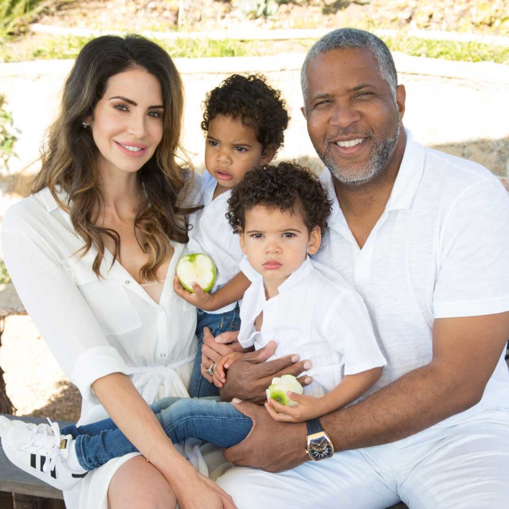 Hope Dworaczyk and Robert F. Smith hold sons for family portrait while dressed in all white.