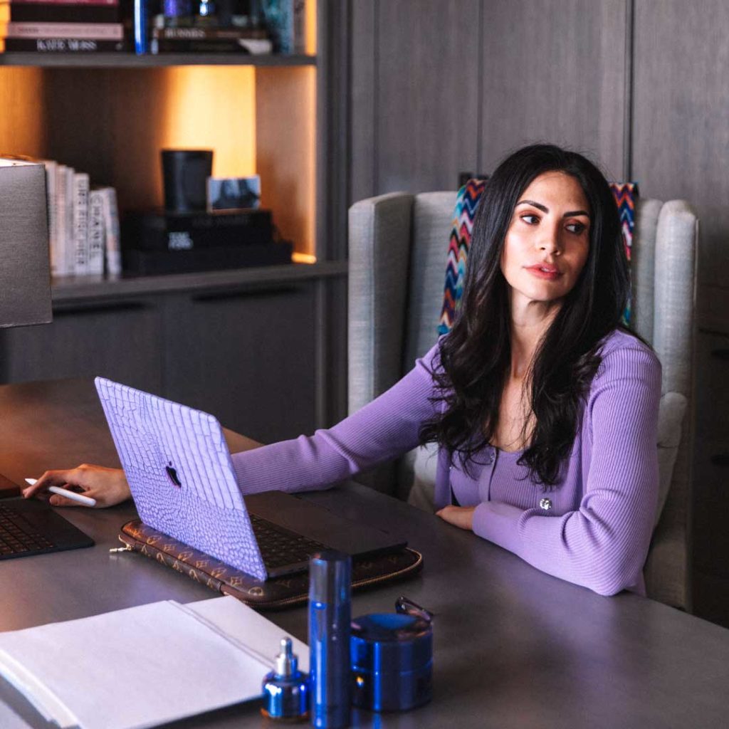 MUTHA™ Founder and CEO Hope Dworaczyk sits at her desk with purple MacBook.