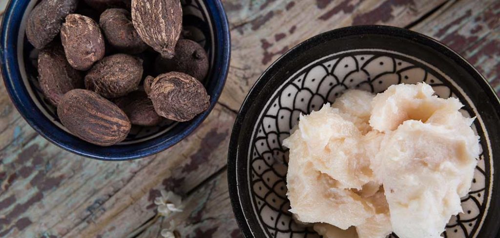 An image of two bowls. One contains shea nuts or seeds and the other shea butter in its final form