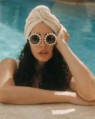 Hope Dworaczyk Smith at the edge of a swimming pool with sunglasses on