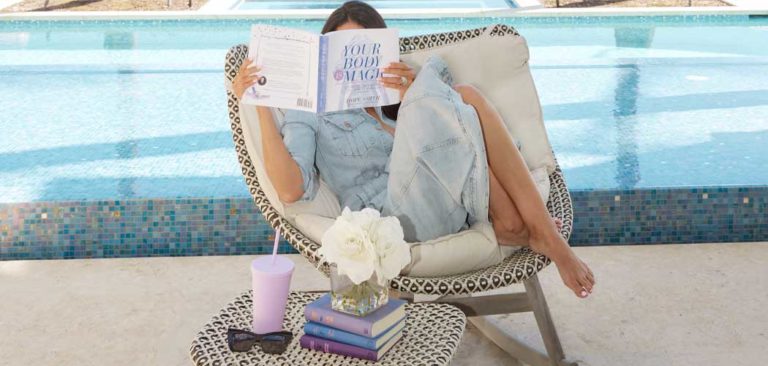 Hope Dworaczyk Smith holding her book Your Body Is Magic: Wellness Strategies for a Healthy Pregnancy