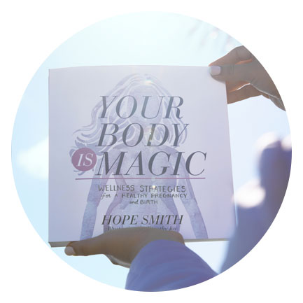 Hope Dworaczyk Smith’s holding her book Your Body Is Magic: Wellness Strategies for a Healthy Pregnancy