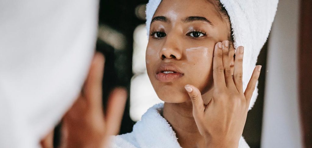 A woman in a towel washing her face