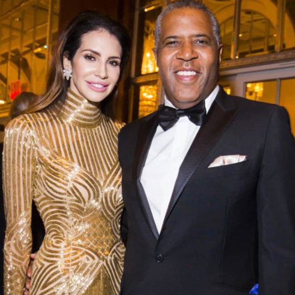 Hope Dworaczyk, in a gold dress with husband Robert F. Smith in a tux