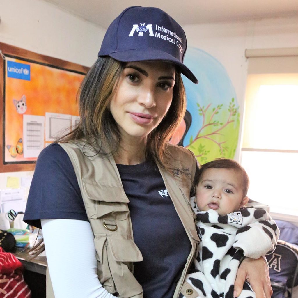 Hope Dworaczyk wears International Medical Corps apparel with a baby in arms while in Jordan
