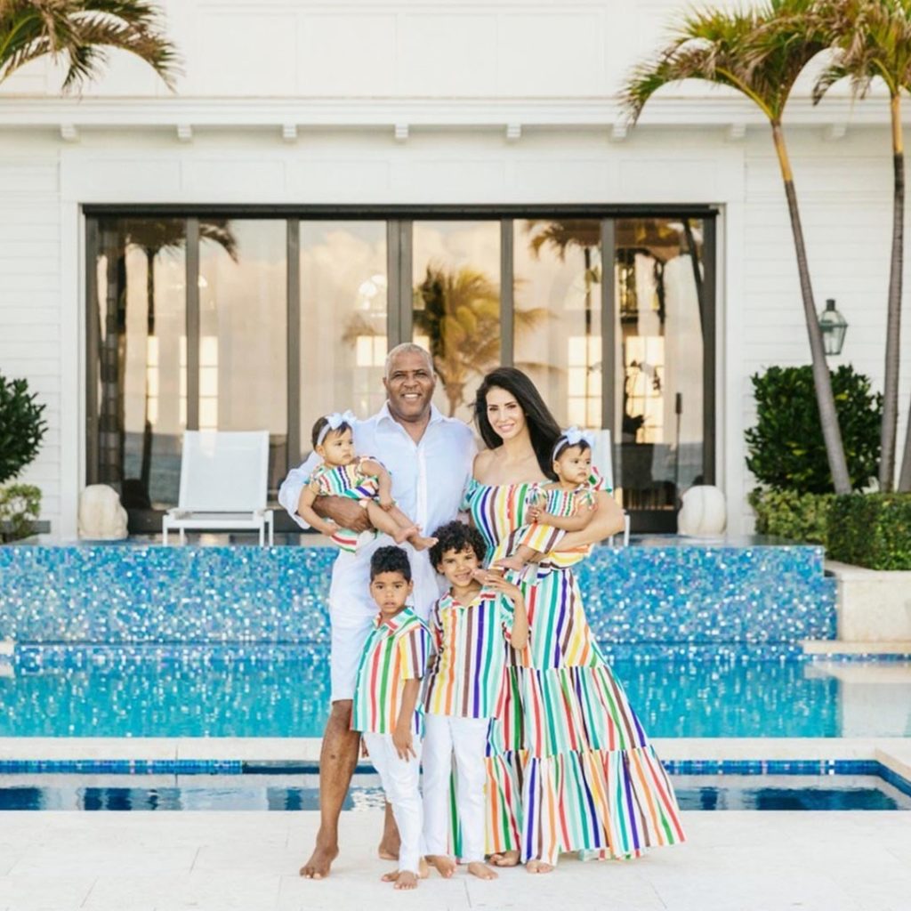 Hope Dworaczyk wears a colorful dress standing with Robert F. Smith and their children