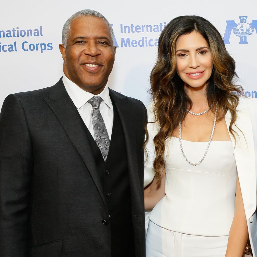 Hope Dworaczyk and Robert F. Smith both smile on the red carpet for a photograph in 2018 at an International Medical Corps event