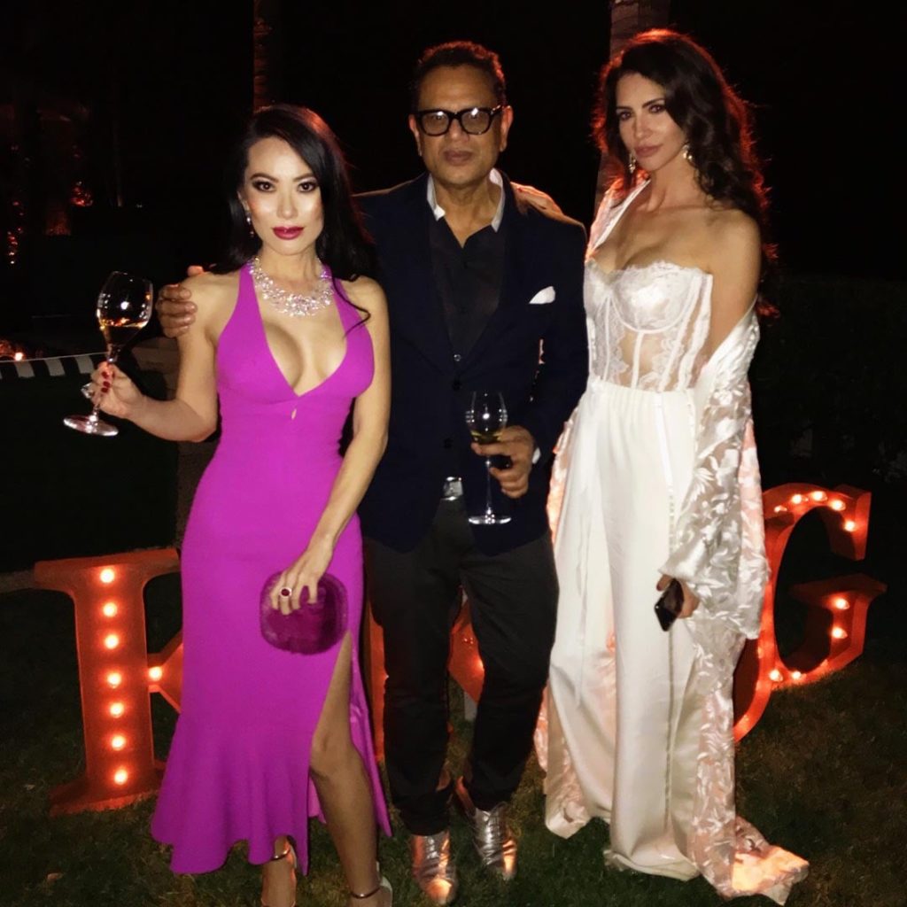 Hope Dworaczyk in white jumpsuit stands next to two other friends