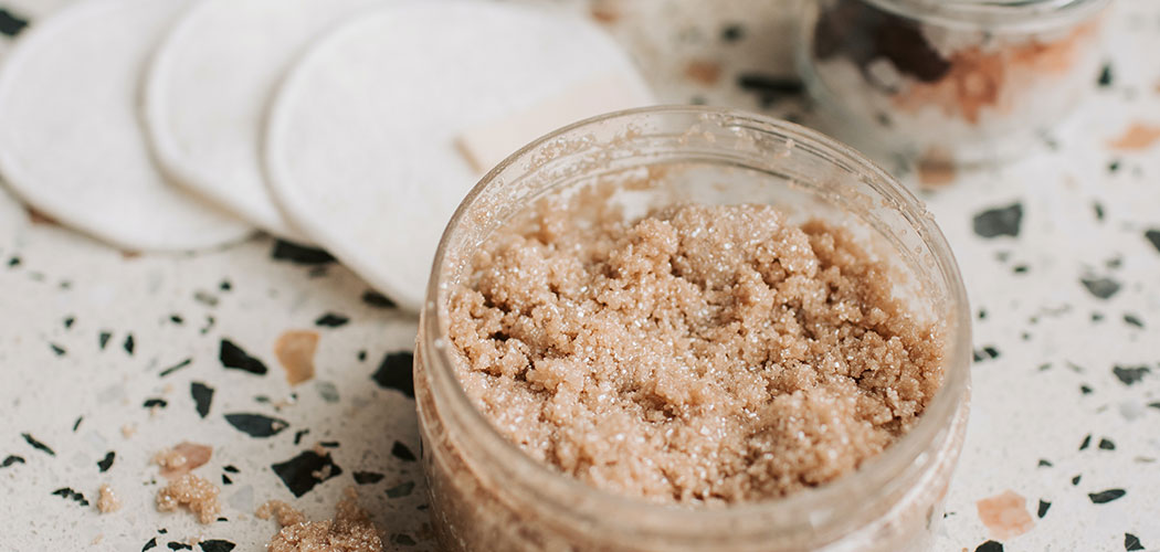 Brown sugar rests in a clear container on a countertop.